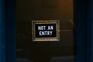 “Not An Entry” posted on a dark door.