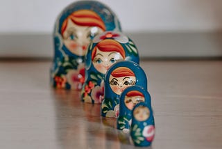 Painted nesting dolls lined up, smallest one in front, largest in back