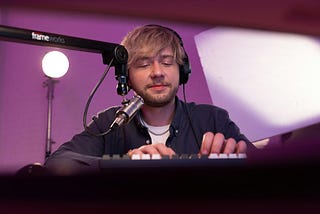 A young YouTuber recording and editing his video or podcast with a professional microphone and a lila background color