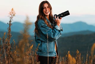 Photo by Jake Johnson on Unsplash of a woman holding a camera