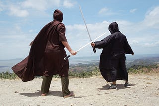 Two people duel on a hilltop