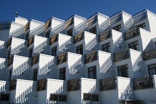 A group of similar-looking white condos against a cloudless blue sky represents how repurposing content can be helpful for creators.