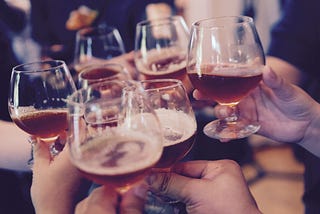 people clinking glasses drinking beers at a party