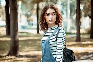 Beautiful contemplative female walking in woods