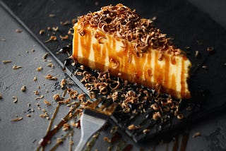 Cheesecake drizzled with caramel and chocolate shavings