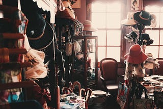 A room filled with clutter and stacked with clothes, hats and books. A representation of the things that your kids don’t want to inherit.