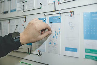 Person working on blue and white paper on board