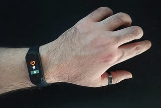 A person wearing a smart ring and a smart band on their hand, showcasing modern wearable health technology.
