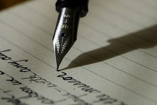 Image of fountain pen writing into a journal or diary