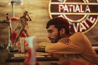A depressed man sitting at a restaurant