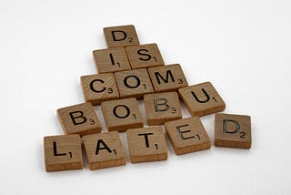 The word “discombobulated” spelled out in Scrabble tiles