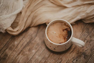 Coffee with cream on rustic wooden table net to cloths. To unplug, or not to unplug. That is the question. Should we unplug from technology.