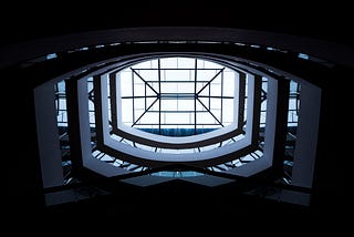 Low-angle photography of white building interior with clear glass roof during daytime this represents brand architecture.
