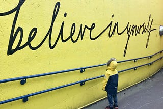 Believe in yourself on a yellow wall.