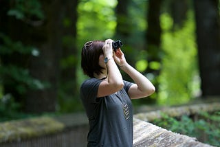 Woman watching smething through binoculars