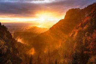 View of the sun setting over the Himalayan Mountains and creating a red glow.