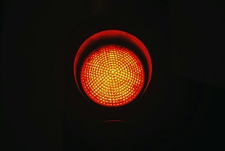 A red stoplight in a dark background