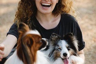 A happy woman posing with two dogs