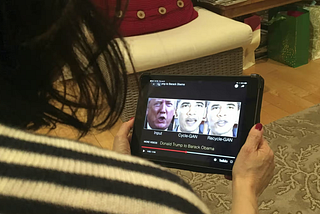 A woman watches a deepfake video of Donald Trump and Barack Obama. Photograph: Rob Lever/AFP via Getty Images