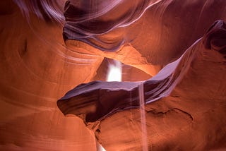 Canyon with shafts of light penetrating to the floor