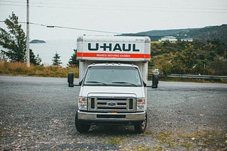 A U-Haul truck off the side of a highway facing the viewer.