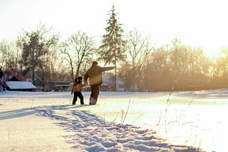 Boy and grandfather enjoying the sunny snowy day