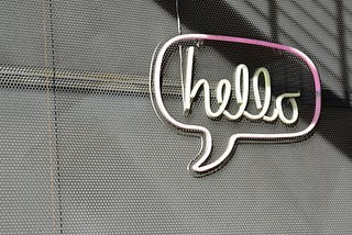 Neon sign of the word hello in a speech bubble.