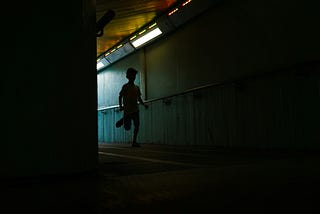 boy running down a shadowy hallway