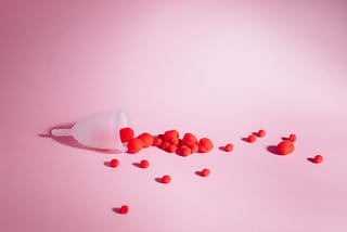 Image of a menstrual cup on a pink surface.