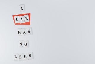 A image with a white background, and the words ‘A lie has no legs’ printed under each other to the left of the image.