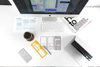 Desk with computers and sketches to show a UX designer’s workspace