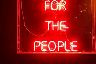 A neon-sign reading “Music for the people” in red.