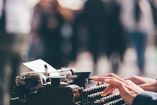 Someone begining to write on an antique type writer.