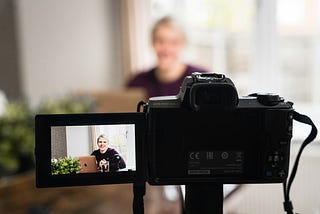 A woman sitting in front of a camera.