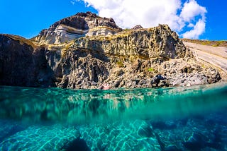 An oceanside view of a cliff and winding road.