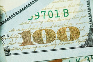 The number 100 is displayed prominently on the corner of a bank note.