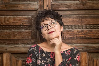 Woman thinking and smiling, looking upward.