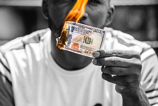 A man burns a $100 note