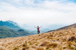 A person celebrating on a mountain top.