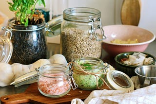 Ingredients, in bowls and open jars, laid out on a wooden surface.
