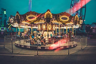 Children enjoying a ride on an old-fashiones carousel.