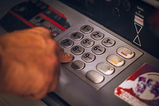 Person’s hand inputting ATM pin number