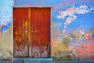 A red door on a colorful wall