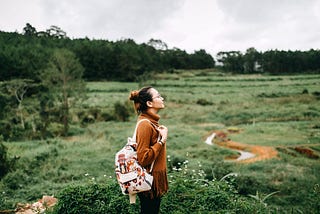 Woman in a field with a backpack