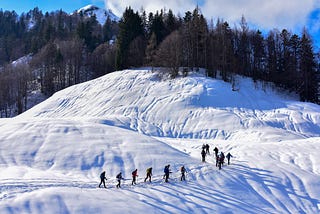 People snowshoeing across a mountain