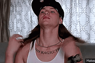 Scene from We’re the Millers where the dim boyfriend reveals his prominent, misspelled tattoo, “No Regrats.”