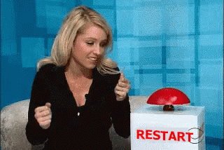 A girl that just realised she messed up, and press a big red Restart button