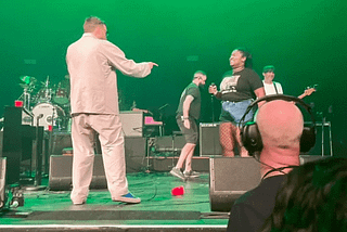 Anaiah Davis and Damon Albarn perform on stage as additional crew look on