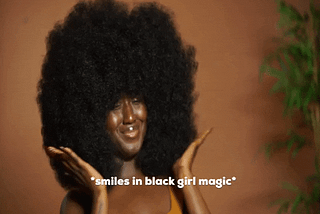 beautiful Black woman smiling with a big afro. text says “smiles in Black girl magic”.