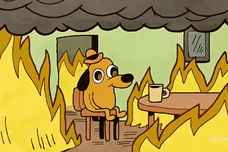 Cartoon of dog in room on fire, drinking coffee, captioned “This is fine.”